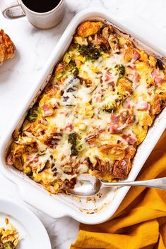 a casserole dish with broccoli, ham and cheese in it on a table