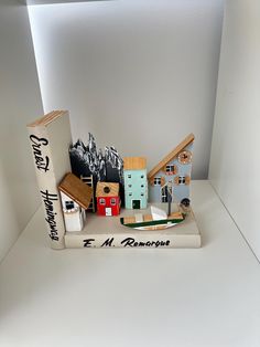 an assortment of miniature buildings and books on a table