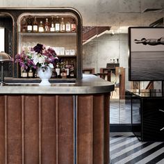 a vase with flowers sitting on top of a bar