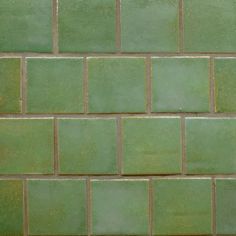 a close up view of a green brick wall