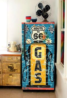 an old fashioned refrigerator is painted blue, yellow and white with the word garage on it