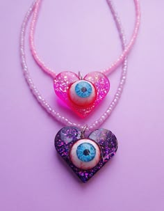 "Fashionable and stylish hippie-style epoxy resin necklace for the most daring and mysterious people. A new large heart-style necklace in various bright colors with sequins will be the best gift for your friends, family or yourself. What distinguishes this product from most conventional jewelry is the mysterious realistic human eye. The eye is completely hand-painted and has no more analogs in the whole world! Do you want to make an unforgettable impression on people? Then the scary and cute necklaces with a \"Heart with an eye\" pendant are just for you. Epoxy resin is a stable and reliable material that does not change over time, does not break, and always looks spectacular. The base of the earrings in the form of a ring with a latch is made of high-quality surgical steel. To make your j Handmade Resin Jewelry, Heart Charm Necklace For Festivals, Trendy Resin Necklaces For Party, Trendy Beaded Necklace With Heart Pendant As Gift, Heart Charm Necklace For Festival, Trendy Heart-shaped Beaded Necklaces For Gifts, Trendy Pink Heart Beaded Necklace, Trendy Handmade Heart Beaded Necklaces, Handmade Heart Pendant Necklace For Party