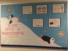 a bulletin board with penguins and snowflakes hanging on it's side in a classroom