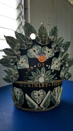 a hat made out of money sitting on top of a blue table