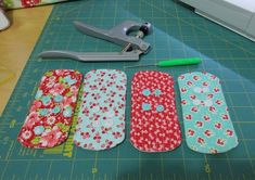 the scissors are laying next to four different patterns on the cutting board, along with some fabric