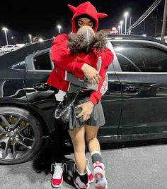 a woman in a devil costume hugging a mannequin on the side of a car