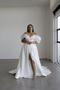 a woman in a white dress posing for the camera