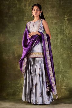 Grey printed kurta highlighted with dori and zardozi work. Paired with printed gharara and purple dupatta.
Component: 3
Pattern: Printed,Embroidered
Type Of Work: Dori and Zardozi Work
Neckline: Round
Sleeve Type: Sleeveless
Fabric: Chanderi Silk, Organza Silk
Color: Grey
Other Details: 
Purple dupatta
Tiered sharara
Embroidered bodice
Occasion: Wedding - Aza Fashions Silk Gharara Designs, Gharara Designs, Punit Balana, Pink Anarkali, Kurta Sharara Set, Kurta Sharara, Anarkali Dress Pattern, Indian Wedding Photos, Silk Outfit