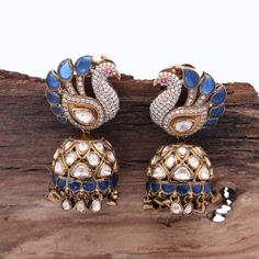 Our breathtaking Peacock Motif Statement Earring, adorned with fine quality Moissanite and a captivating Blue stone that exudes elegance and sophistication. Meticulously crafted in 925 Silver, this earring mirrors the authenticity of Indian Polki style, accentuated by high carat gold-plated silver. The omega hook and push-back closure ensure a secure and robust stud, making it an exquisite choice for weddings or evening soirees. Elevate your festive ensemble or gift this remarkable Diwali present to yourself or a loved one. Gross Weight: 43.78 gms Dimensions: 52 x 25mm Explore more exquisite pieces at our [Etsy Shop](https://www.etsy.com/in-en/shop/TempusGems). Explore more in our shop: [TempusGems](https://www.etsy.com/in-en/shop/TempusGems) Packaging and Shipping We take great care to en Formal Peacock Design Drop Earrings, Blue Cutdana Earrings For Wedding, Blue Cutdana Wedding Earrings, Fusion Style Peacock Design Earrings For Wedding, Fusion Style Wedding Earrings With Peacock Design, Fusion Wedding Earrings With Peacock Design, Elegant Chandbalis With Peacock Design For Diwali, Elegant Sterling Silver Earrings For Diwali, Elegant Sterling Silver Earrings With Peacock Design