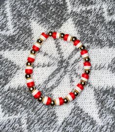 Red and white beads with gold balls  This is a size 7.5 inches bracelet can be made bigger or smaller. If you need a different size, please put a description of what size you need. Kids-6.5 Woman-7.5 Men-8.5 Festive White Beaded Bracelets With Colorful Beads, White Letter Beads Bracelets For Holidays, White Bracelets With Colorful Beads For Christmas, White Christmas Bracelets With Colorful Beads, Christmas White Bracelets With Colorful Beads, White Beaded Bracelet For Christmas, White Adjustable Beaded Bracelets For Holidays, Adjustable White Beaded Bracelets For Holiday, White Round Bead Bracelets For Holiday