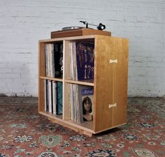 a record player sitting on top of a wooden shelf