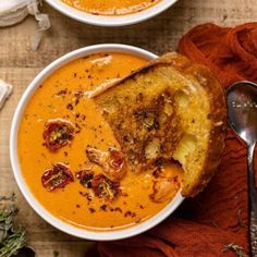 two bowls filled with soup on top of a wooden table