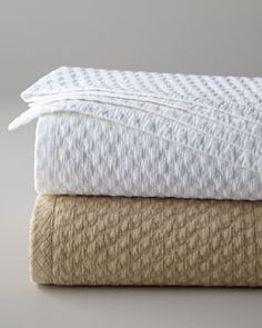 three white towels stacked on top of each other in different sizes and colors, with the words village - interiors written below them