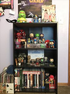 a book shelf filled with lots of toys and action figures on top of bookshelves