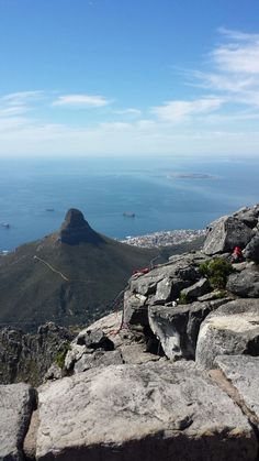 a view from the top of a mountain looking down at some water and mountains in the distance