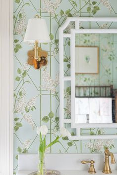 a white sink sitting under a bathroom mirror next to a wall mounted faucet