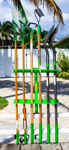 a sculpture made out of wooden sticks and green paint on the outside of a house