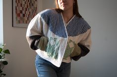 a woman standing in front of a window with her hand on her hip and looking at the camera