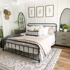 a bedroom with a bed, dressers and mirrors on the wall above it's headboard