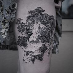 a woman's leg with an umbrella tattoo design on her left thigh, and flowers in the background