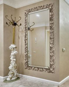 a large mirror in the corner of a room next to a vase with flowers on it