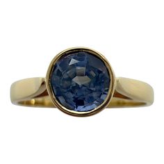 Vivid Light Blue Ceylon Sapphire Round Cut 18k Yellow Gold Solitaire Rubover Bezel Set Ring. 1.00 Carat sapphire with a stunning vivid light blue and good clarity. Clean stone with only some small natural inclusions visible when looking closely. No breaks or cracks. This sapphire has an excellent round brilliant cut which shows lots of sparkle and light return. Looks even better in person. Sapphire measures 5.8mm. Set in a fine 18 karat yellow gold rubover solitaire ring. Top grade piece. Ring s Elegant Yellow Gold Sapphire Cabochon Ring, Blue Cabochon 14k Gold Ring, 14k Gold Round-cut Sapphire Ring, Heirloom Yellow Sapphire Round Jewelry, Classic Round Cut Yellow Sapphire Jewelry, Ceylon Sapphire Ring, Yellow Gold Solitaire Ring, Ring Jewellery Design, Yellow Gold Solitaire