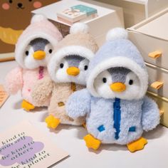 three stuffed penguins are sitting next to each other