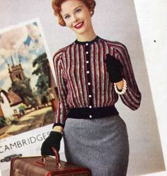 a woman in striped shirt and skirt holding a suitcase