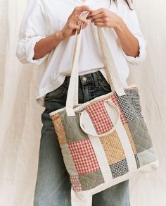 a woman is holding a handbag made out of patchwork fabrics and fabric material