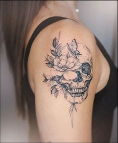 a woman with a skull and flowers tattoo on her shoulder