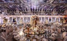 an elaborately decorated banquet hall with chandeliers and tables