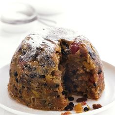 a white plate topped with a muffin cut in half on top of a table