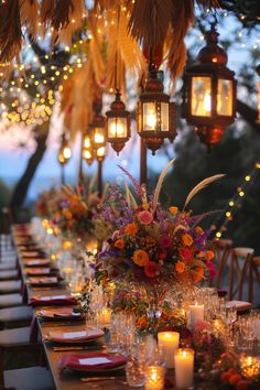 a long table is set with candles and flowers for an outdoor dinner party in the evening