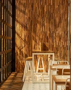 the interior of a restaurant with wooden walls and white tables, chairs and stools