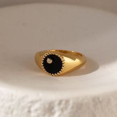 This modern signet ring is sure to get noticed with its bold design and stunning black color. The deep black background and thick ring band is an elegant contrast to the delicately embedded CZ Diamond. It’s both elegant and edgy, making it perfect for any occasion or style. Material: High Quality Solid 925 Sterling Silver Finish: 18K Gold∙Sterling Silver Featuring a ~10mm Black Enamel Signet Ring with an embedded CZ Diamond | Band is ~2.5mm Model showcases a statement, everyday style ring look f Elegant Black Enamel Ring For Promise, Minimalist Black Rings For Formal Occasions, Luxury Black Tarnish-resistant Ring, Luxury Black Signet Ring Tarnish Resistant, Minimalist Open Ring With Black Enamel, Classic Black Open Signet Ring, Black Classic Open Signet Ring, Modern Black Round Rings, Black Tarnish Resistant Signet Ring For Formal Occasions