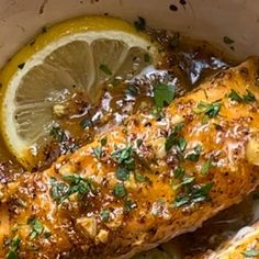 baked fish with lemon and herbs in a white bowl