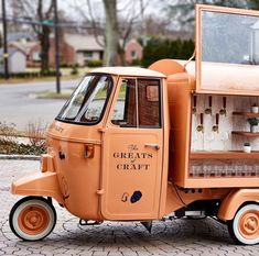 an orange truck is parked on the side of the road with its door open and shelves full of bottles