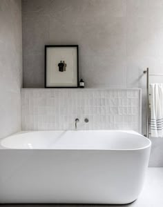 a white bath tub sitting in a bathroom next to a sink