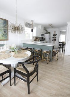 a dining room table and chairs in front of a kitchen island with an island counter