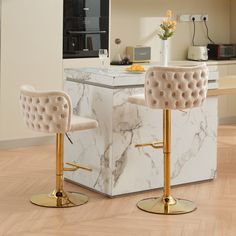 two stools that are sitting in the middle of a kitchen area with marble counter tops