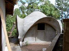 an outdoor area with a stone structure and trees in the background