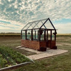 a small greenhouse in the middle of a field