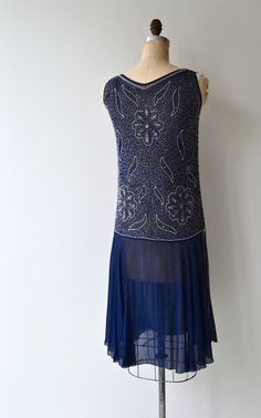 "Vintage 1920s deep blue silk dress with clear and grey bugle beading in floral pattern, classic jazz age unfitted cut with unadorned fluttery skirt panels on each side as well as the back. No closures, slips on easily over the head. [m e a s u r e m e n t s] fits like: small/medium bust: 34-36\" waist: best fit up to 31\" hip: 38\" length: 42\" [i n f o] brand/maker: n/a fabric content: silk condition: excellent (some missing beads on back at the collar, see photo) to ensure a good fit, please 1920s Embellished Sleeveless Flapper Dress, 1920s Embellished Summer Dresses, 1920s Style Embellished Summer Dresses, Embellished 1920s Style Summer Dresses, 1920s Style Summer Flapper Dress, Fitted Blue Flapper Dress, Blue Fitted Sleeveless Flapper Dress, Fitted Blue Flapper Dress For Summer, 20s Flapper Dress