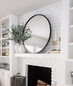 a living room with a fire place and a mirror on the wall next to it