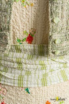 an old pair of gloves hanging on the back of a chair with flowers all over it