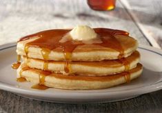 a stack of pancakes covered in syrup and butter