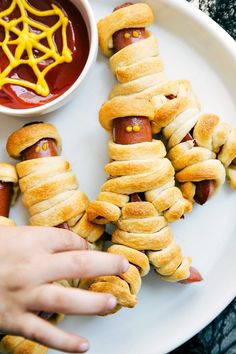 hot dogs wrapped in crescented bread on a white plate