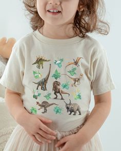 Dinosaur Shirt for Kids Gender Neutral Kids Clothes TRex Shirt BOHO Dino Tshirt Girl Dinosaur Shirt Boy Dinosaur T Shirt Matching Mom Shirts A trendy cottagecore dino tee!  Sure to be a new favorite conversation starter for your reptile lover!  Want to match? Check our shop for baby and adult sizes in this print!  * Q U I C K * F A C T S * * T E E S * ✺ 100% preshrunk cotton ✺ Heather colors are 52% combed and ring-spun cotton, 48% polyester ✺ Athletic Heather is 90% combed and ring-spun cotton, 10% polyester ✺ Inside out and wash and dry on cool for best results.  Do not iron decoration. ✺ printed using DTG Direct to Garment printing.  ✺ Colors may vary due to computer monitors and printing inks. ✺ While we offer several shirt colors some may have a better contrast with the design. Keep t Casual Green Dinosaur Print Tops, Casual Green Tops With Dinosaur Print, Casual White Shirt With Dinosaur Print, White Long Sleeve Dinosaur Print Top, White Long Sleeve Top With Dinosaur Print, Unisex Dinosaur Print Crew Neck Top, Short Sleeve White Tops With Dinosaur Print, White Short Sleeve Tops With Dinosaur Print, White Short Sleeve Top With Dinosaur Print