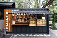 an outside view of a food stand that is black and white with the words le avenue written on it