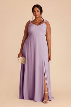 a woman in a long purple dress posing for the camera with her hand on her hip